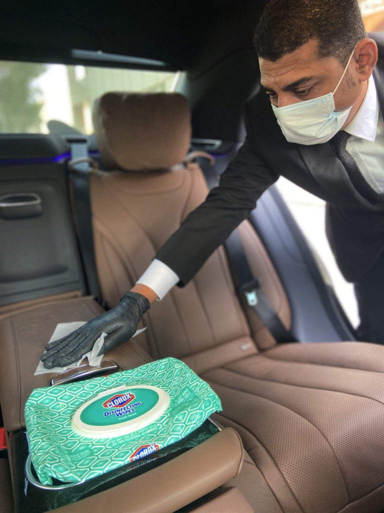 Driver in mask cleans car interior