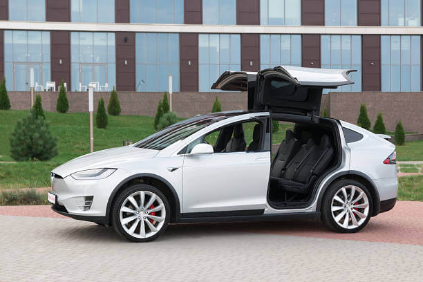 White Tesla X for hire with opened doors